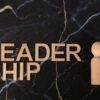 Wooden leadership text and figurine on marble representing management concepts.